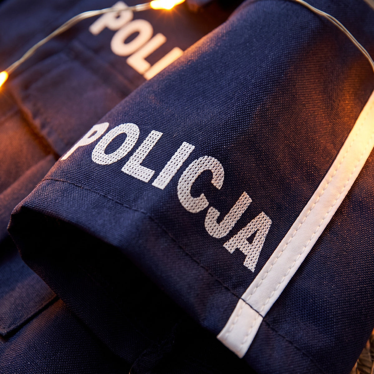 Strój policjanta dla dziecka, koszula, spodnie, czapka i pałka, detail macro